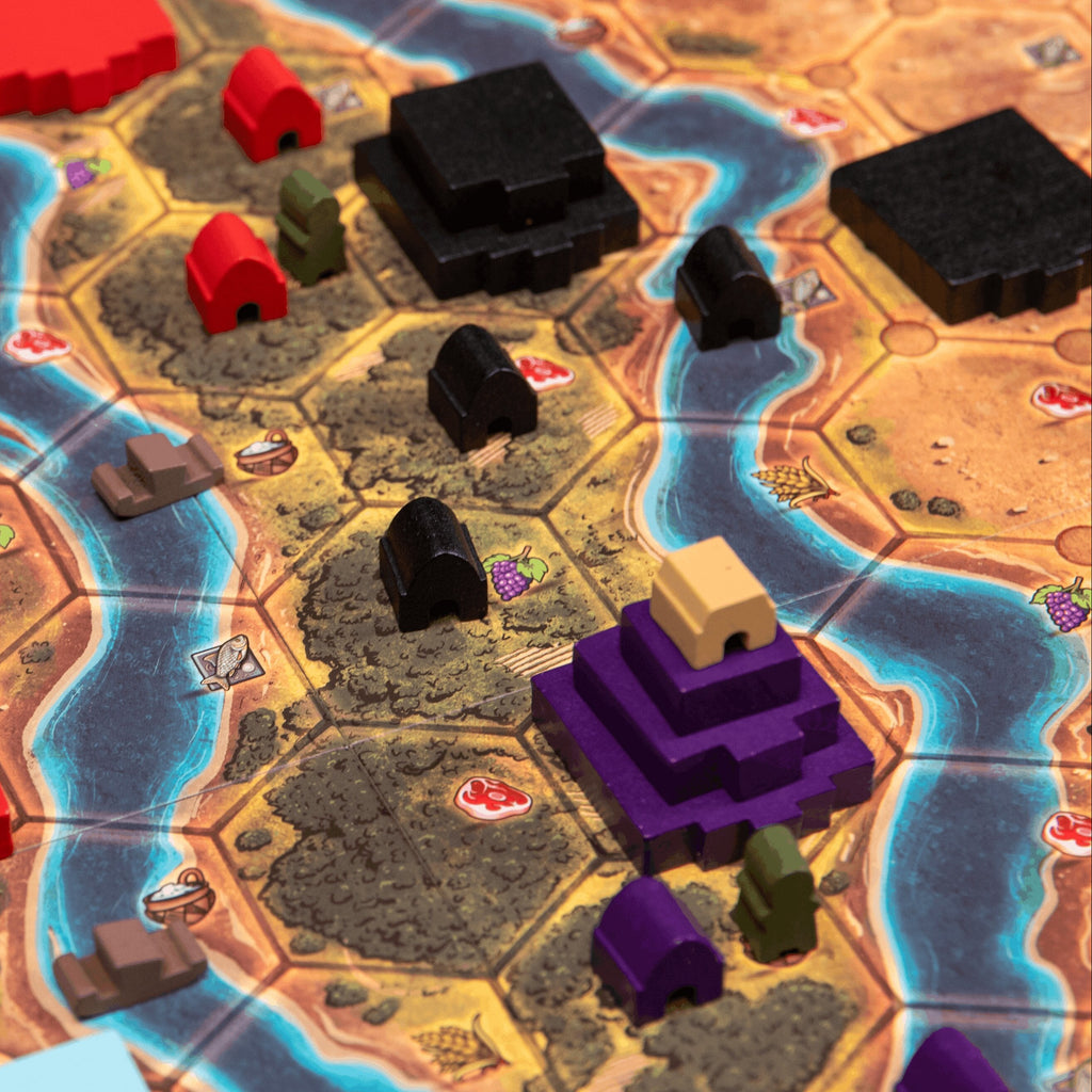Board game setup with colorful hexagonal tiles and player pieces on a detailed map.
