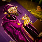 Card game piece with a character in a purple robe and helmet, holding a sword, on a dark background.