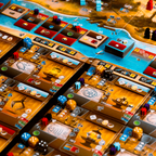 Close-up of a board game with various pieces and dice on a wooden table.