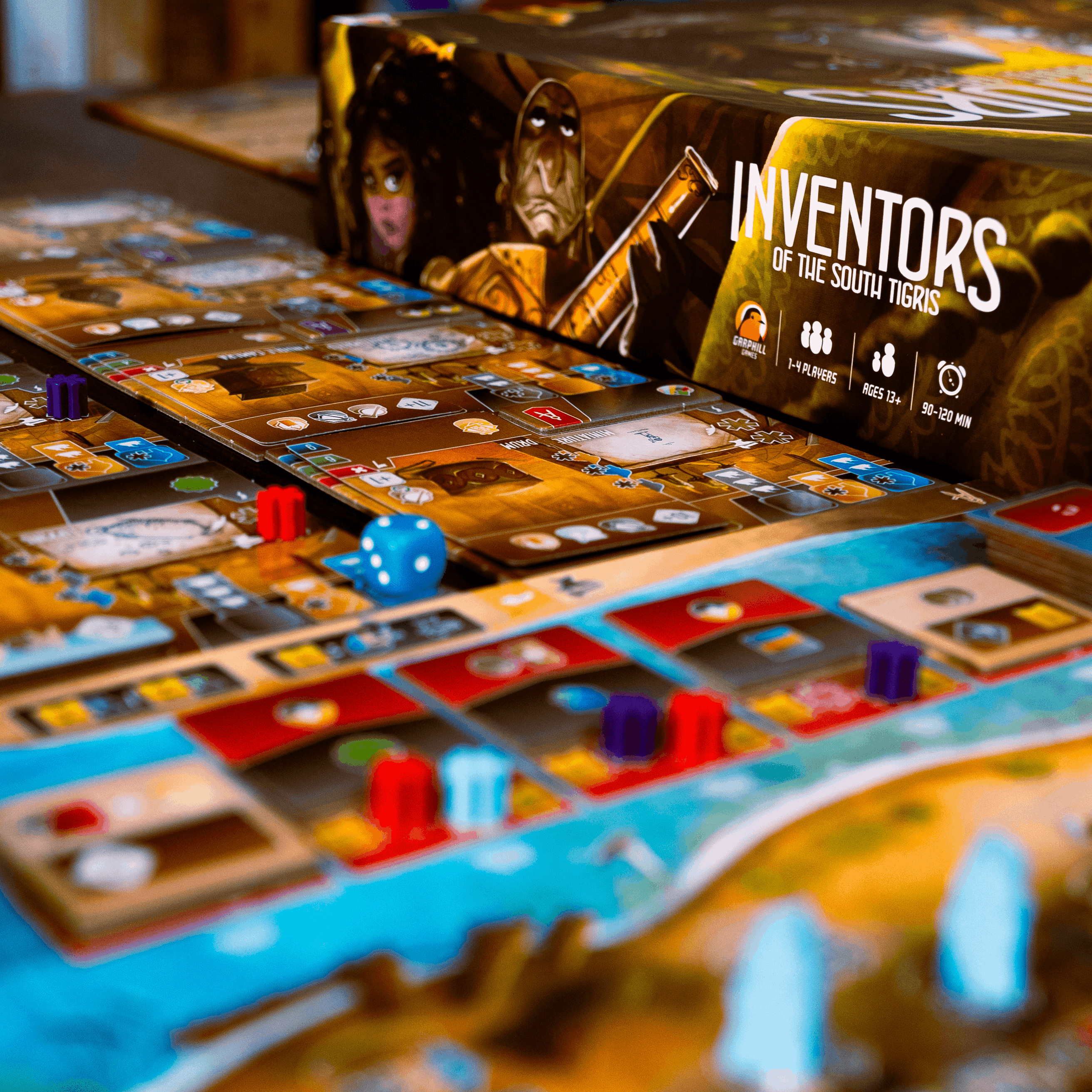 Board game with cards and dice on a table, featuring 'Inventors of the Southlands' box.