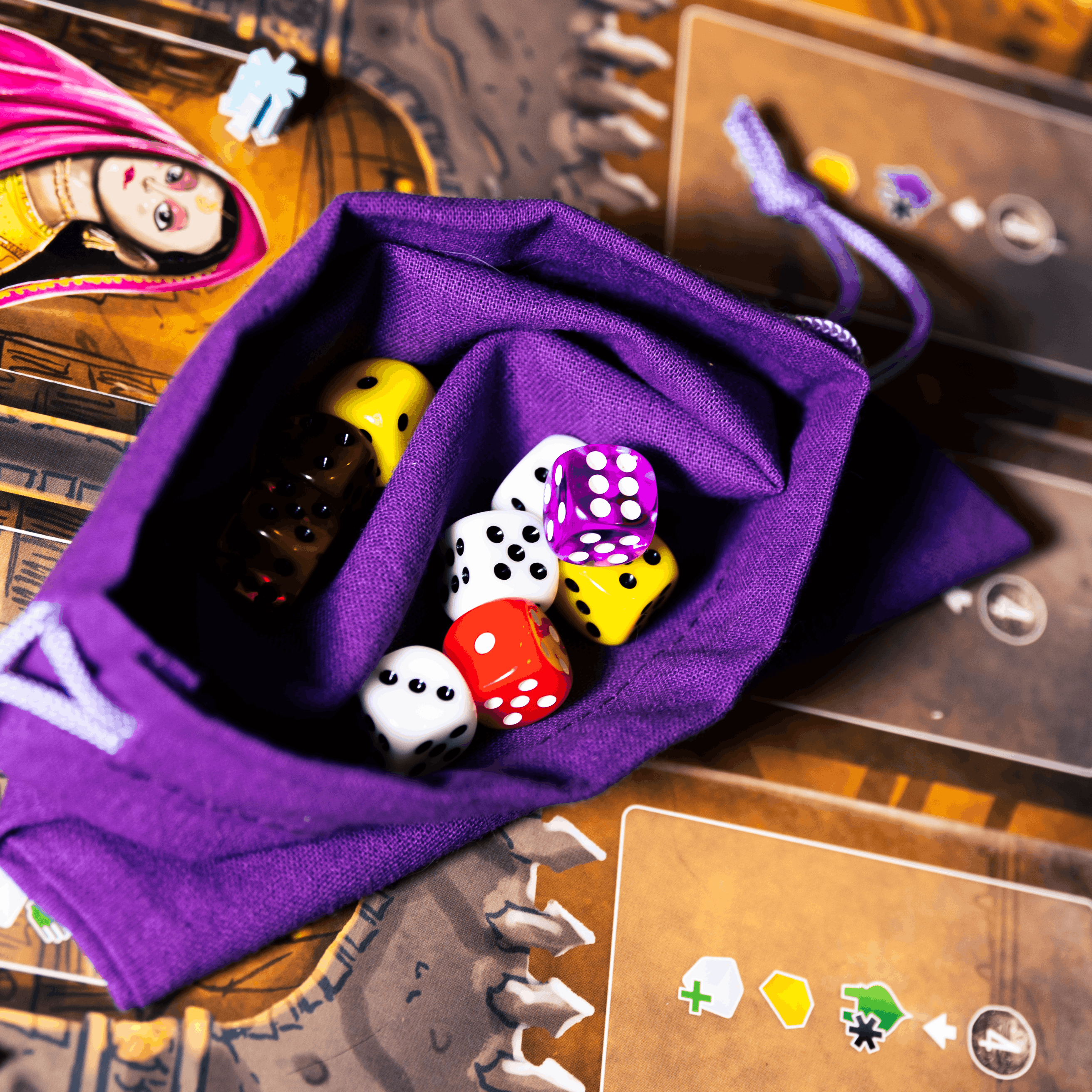 Purple drawstring bag with dice on a board game surface